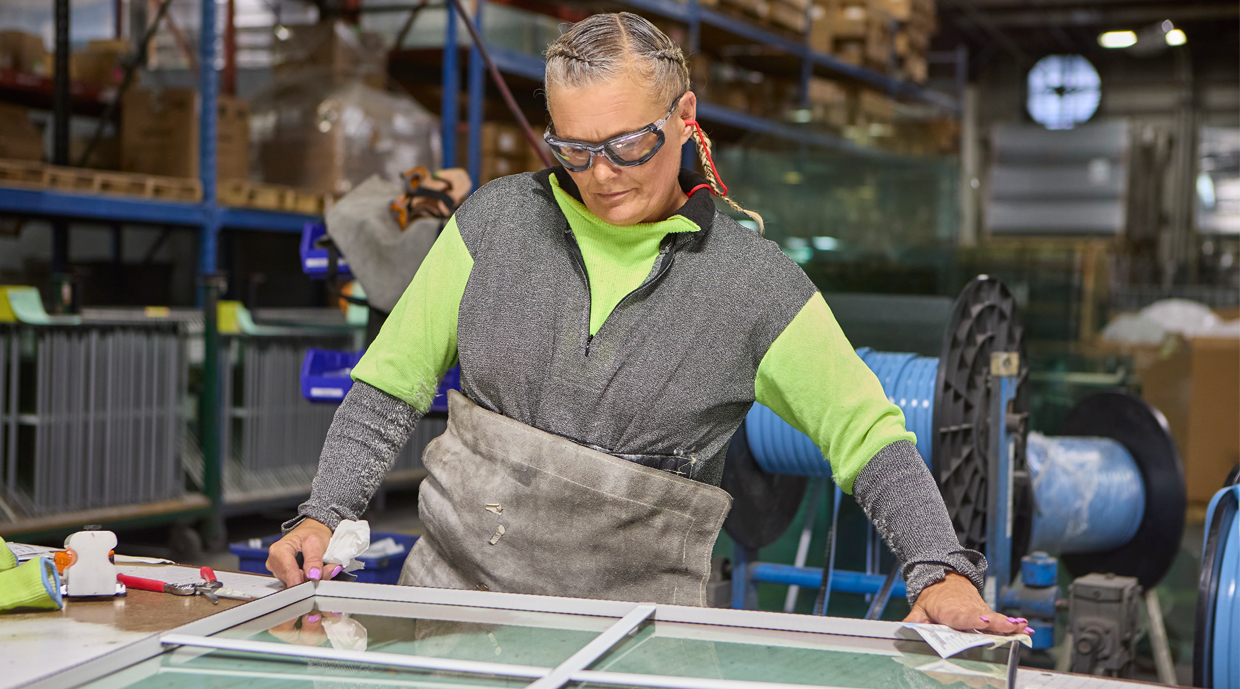 A worker is examining the window with grilles.